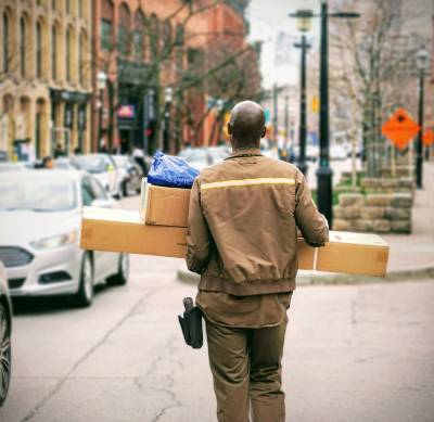 person carrying packages on a bustling city street